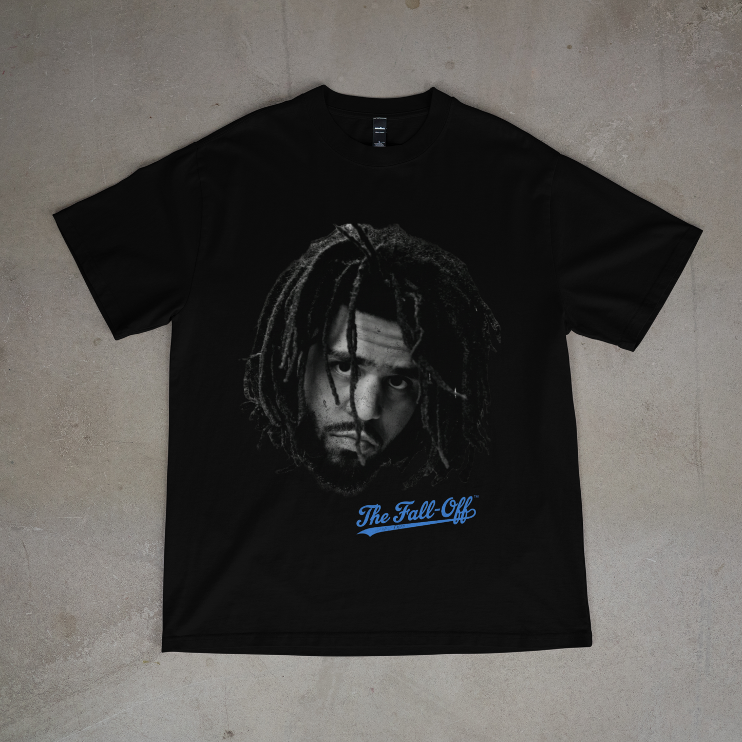 Black t-shirt with a graphic design and text on a beige surface