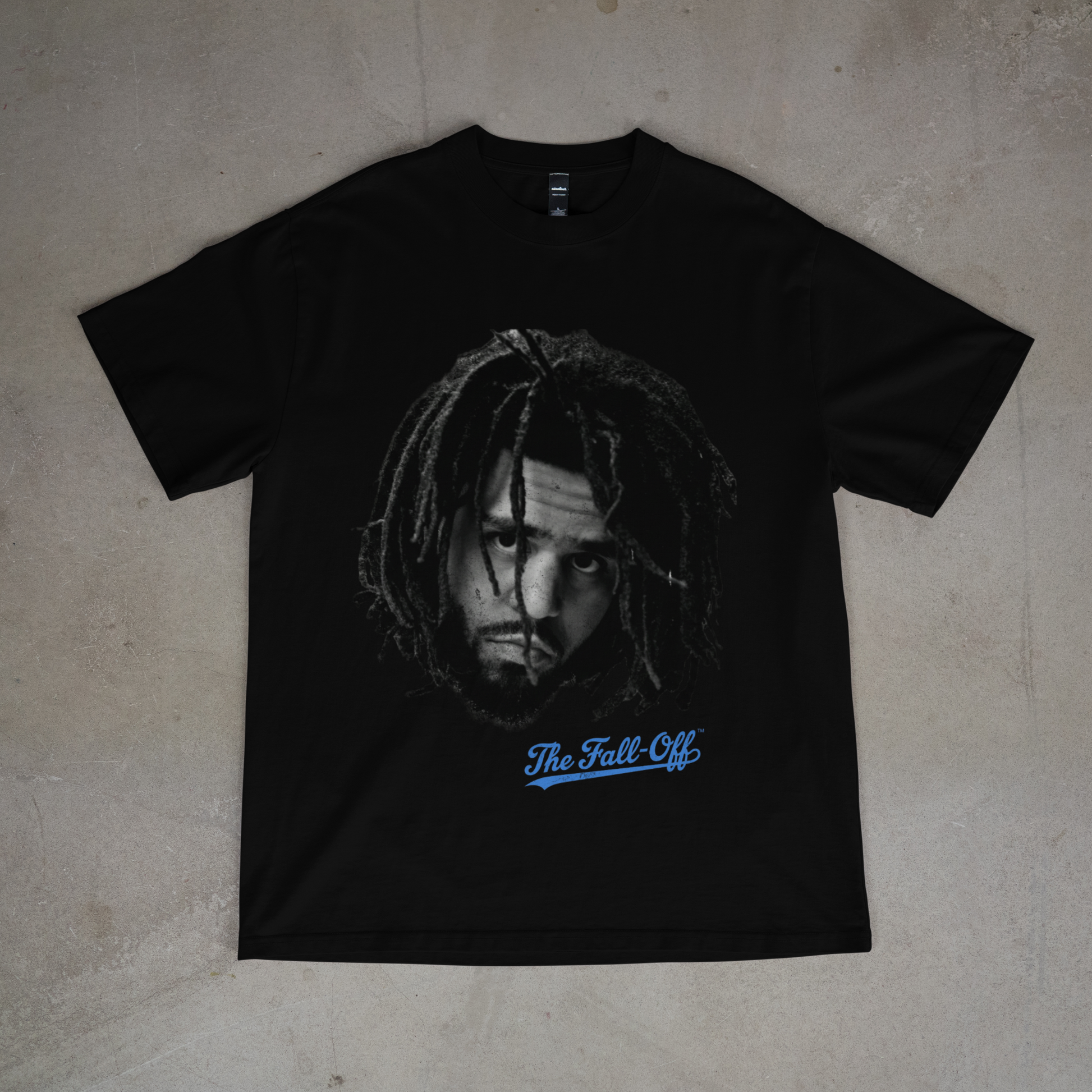 Black t-shirt with a graphic design and text on a beige surface