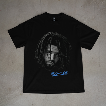 Black t-shirt with a graphic design and text on a beige surface